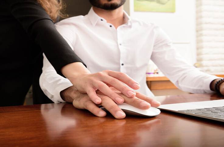 Woman grabbing mans hand at work - Sexual Harassement